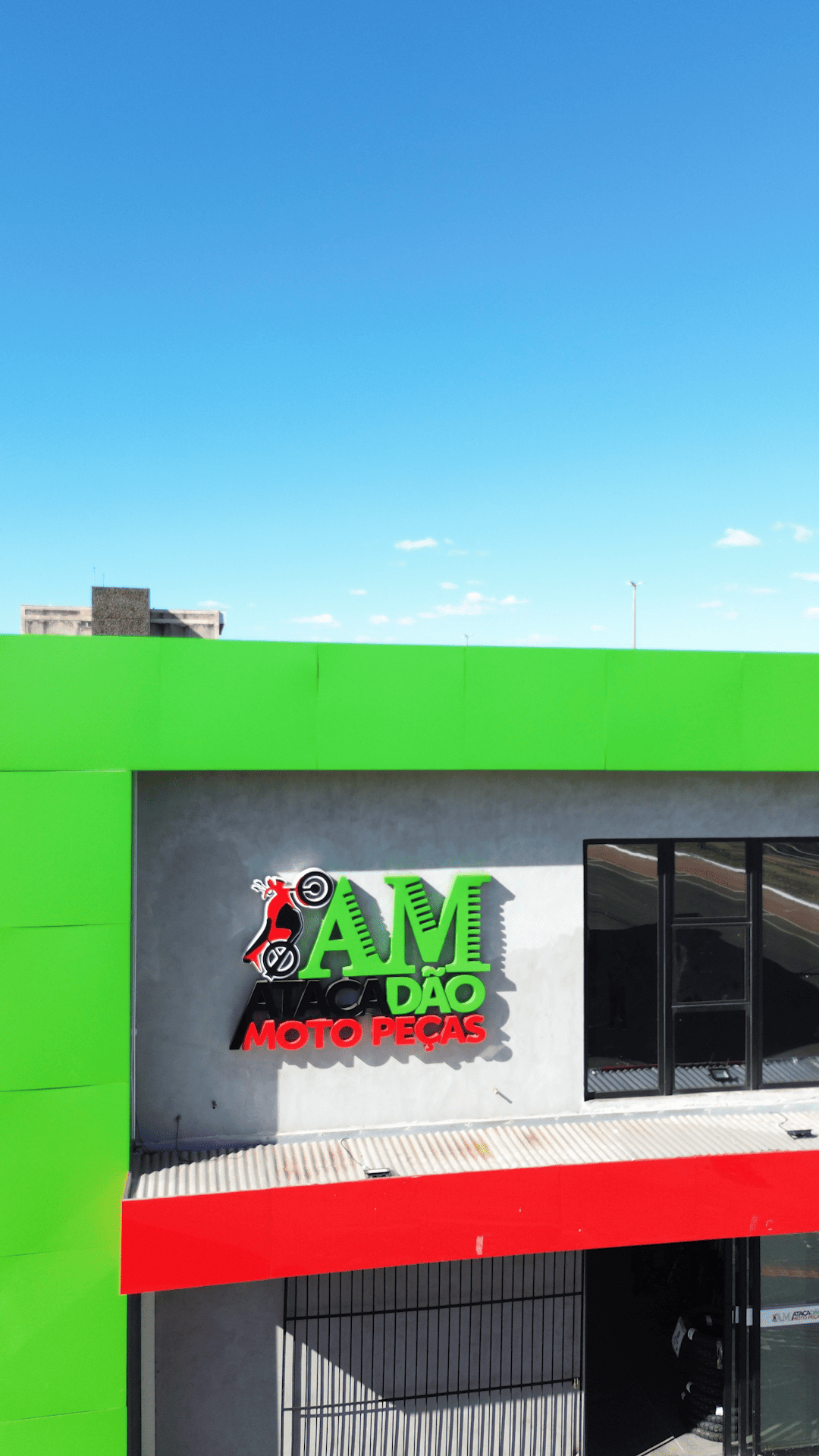 Detalhe da logomarca AM Atacadão Moto Peças na fachada da loja